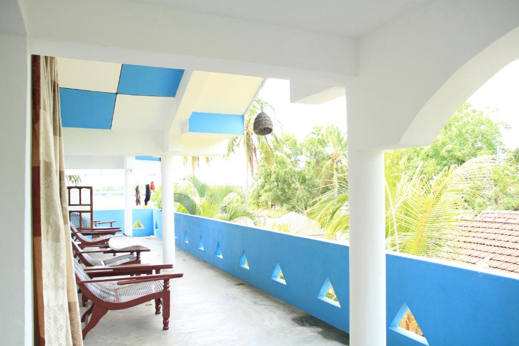 una habitación con sillas y una pared azul y blanca en swell surf house, en Arugam Bay