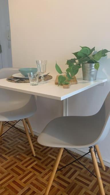 a white table with a chair and plants on it at Apt 20 min from downtown train in Amadora