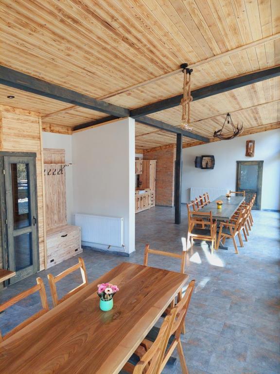 a dining room with a wooden table and chairs at Cazare Nemes Szállás in Joseni