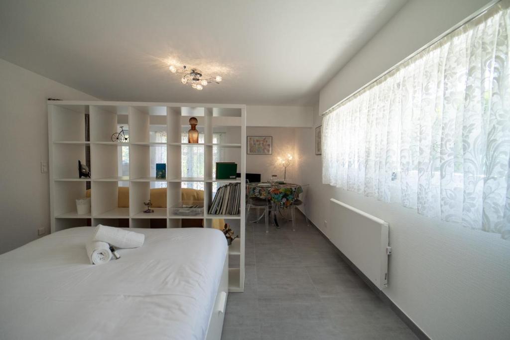 a bedroom with a white bed and a window at Les cerisiers un petit coin de paradis pour deux proche du lac! in Sévrier