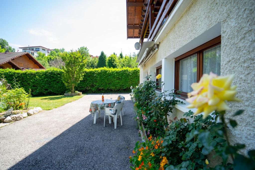 a patio with a table and chairs outside of a house at Les cerisiers un petit coin de paradis pour deux proche du lac! in Sévrier