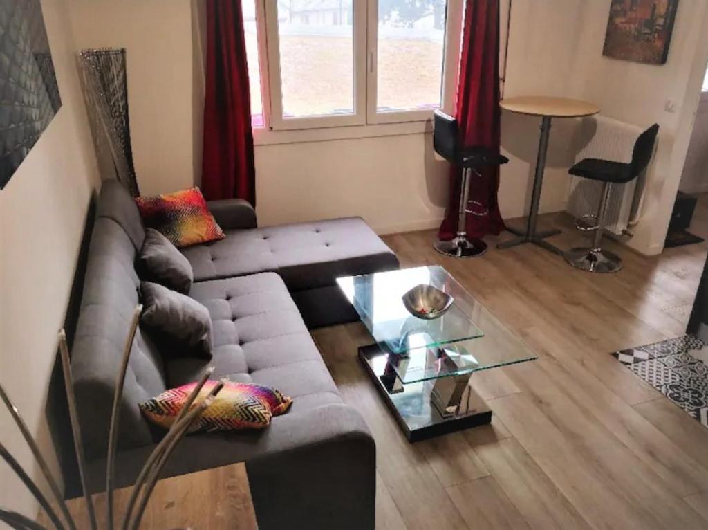 a living room with a couch and a glass table at CHARMANT & PRATIQUE, 2 Pièces/4 Pers à 15 min de Paris et Versailles in Ville-dʼAvray