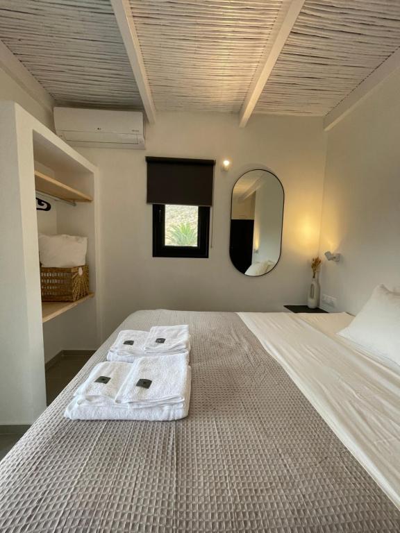 a bedroom with a large white bed with a mirror at Vie rêvée luxury suites in Ganema