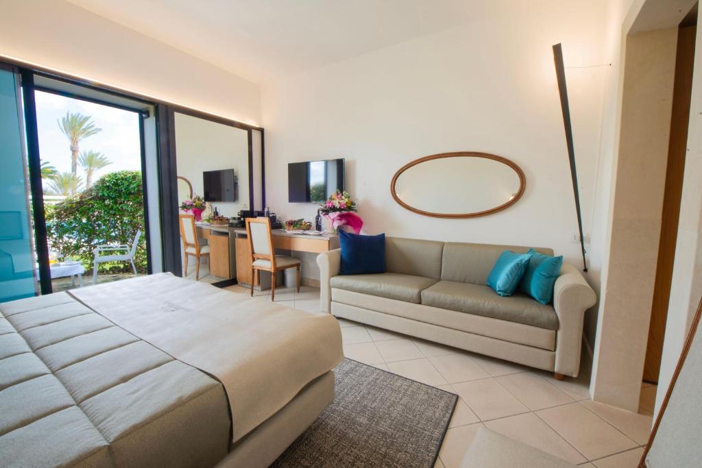 a living room with a bed and a couch at Grand Hotel Masseria Santa Lucia in Ostuni