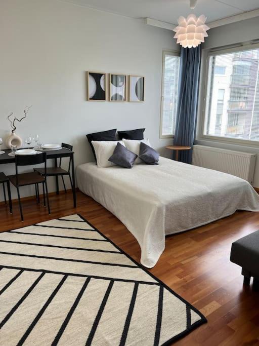 a bedroom with a large bed and a table at Studio by Sello shopping mall in Espoo