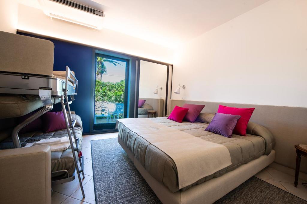 a bedroom with a bed with pink pillows and a window at Grand Hotel Masseria Santa Lucia in Ostuni