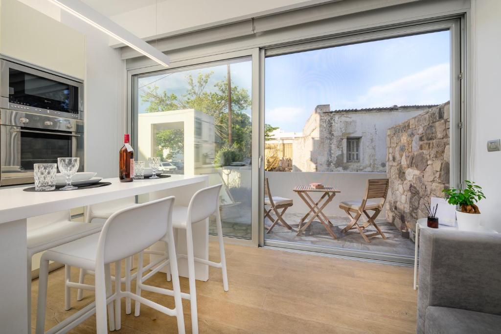uma cozinha com mesa e cadeiras e uma grande janela em Michelangelo City Luxury Lodge em Cidade de Kos