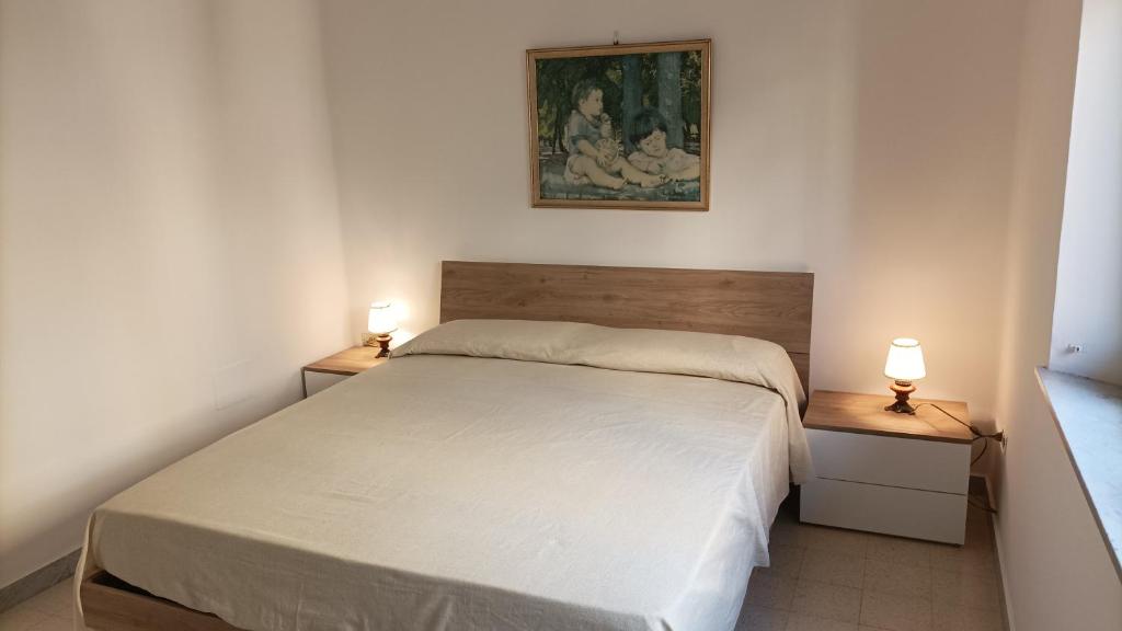 um quarto com uma cama e duas lâmpadas em duas mesas em Vela Latina em Soverato Marina