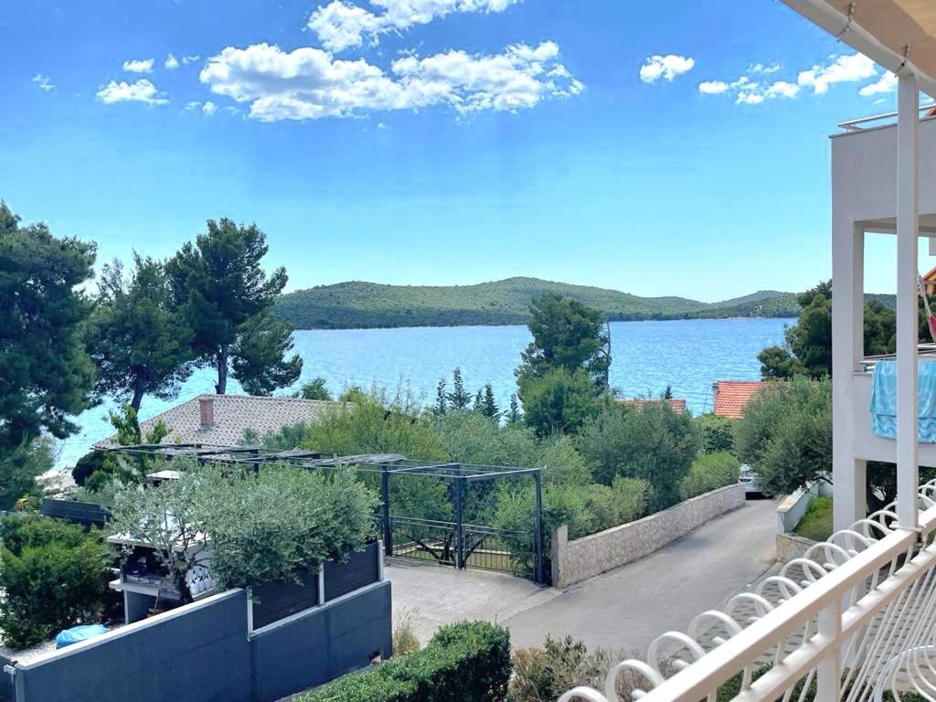 uitzicht op het water vanaf het balkon van een huis bij Apartman MR in Zaboric