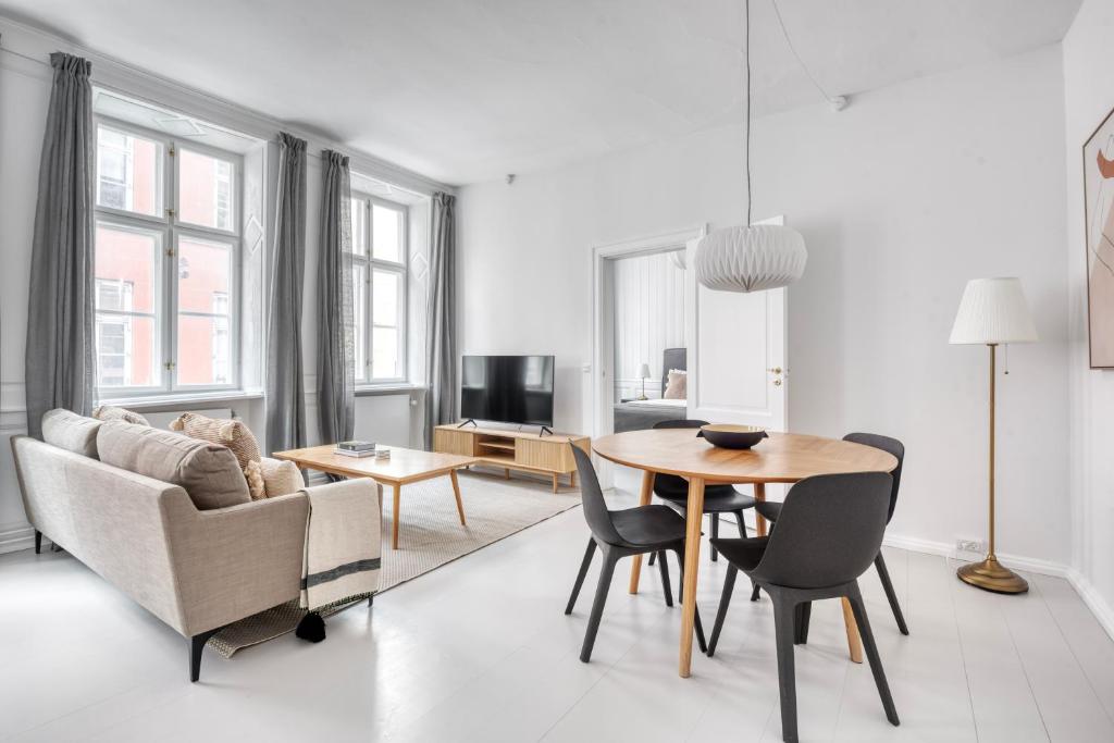 salon ze stołem, krzesłami i kanapą w obiekcie Cozy Flats in Heart of Copenhagen Near Strøget & Højbro Plads w Kopenhadze