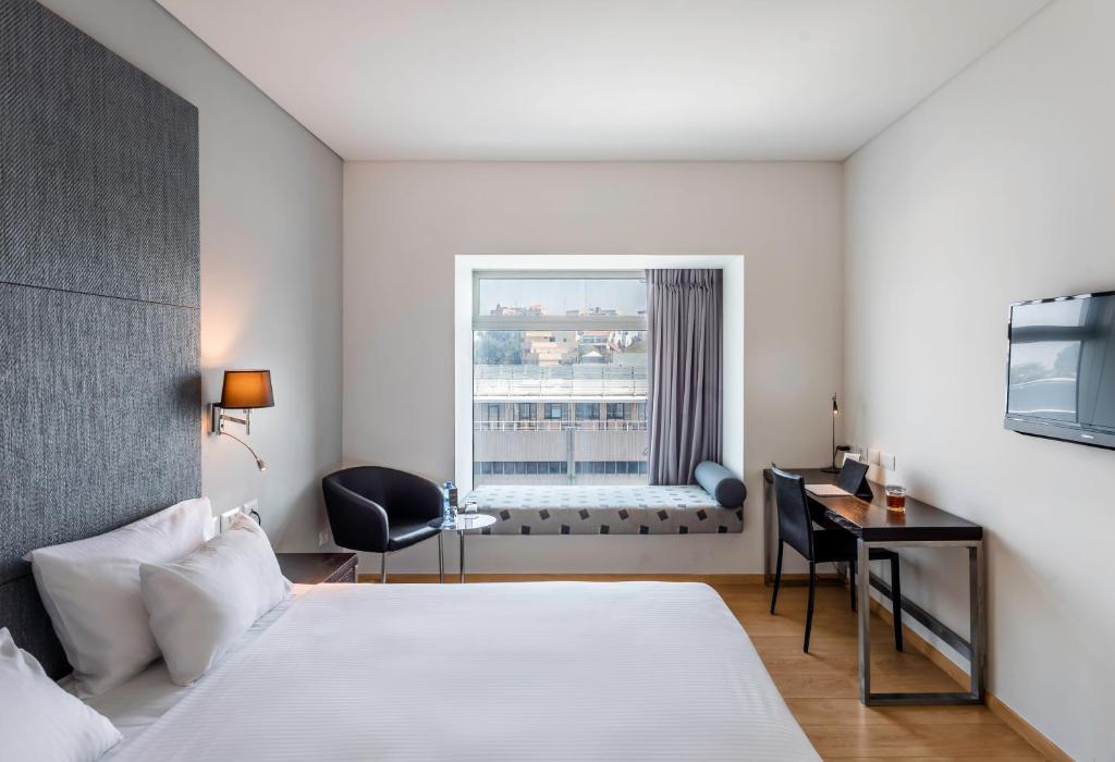 een hotelkamer met een bed en een raam bij Benjamin Business Hotel in Herzelia 