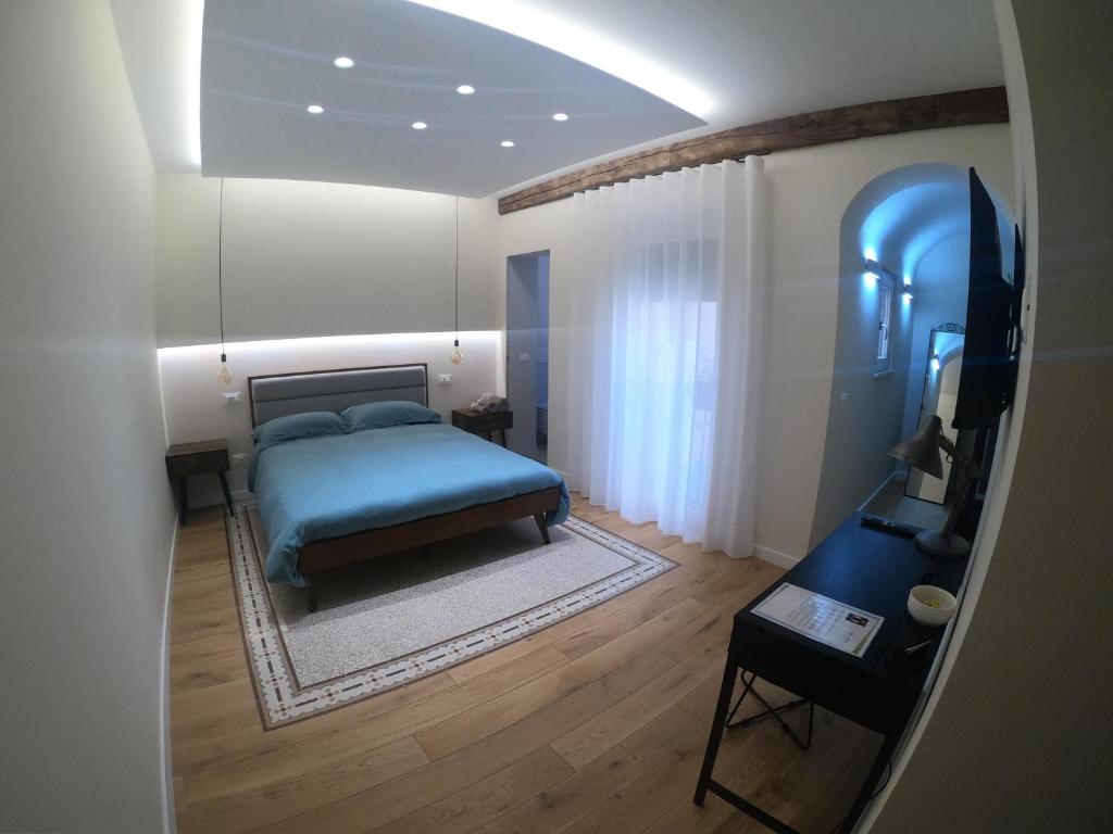 a bedroom with a blue bed and a table at Il Palazzotto in Castel di Sangro