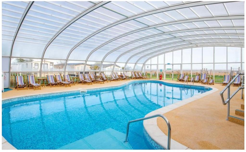 a large swimming pool with a glass roof at Caravan on Mersea Island Away Resorts Quiet Location in East Mersea