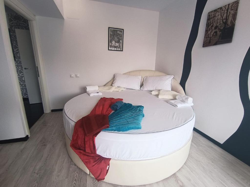 a round bed with a pile of clothes on it at Central Apartments in Bucharest