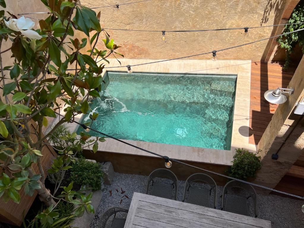 an overhead view of a swimming pool with a table and chairs at Can Met Mosso, Casa rural, Piscina Climatitzada Privada in Albóns