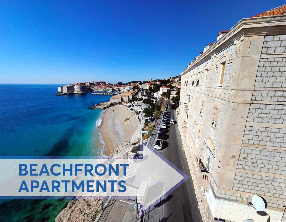 vistas a la playa desde un edificio con un cartel que lee apartamentos frente al mar en The Beachfront Dubrovnik Old Town, en Dubrovnik