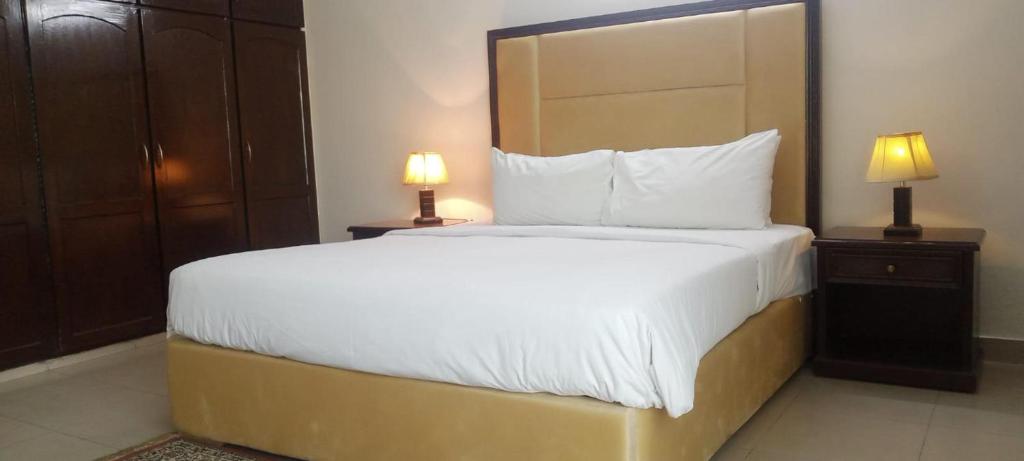 a large bed in a hotel room with two lamps at Impeccable 3-Bed Apartment in Lahore in Lahore
