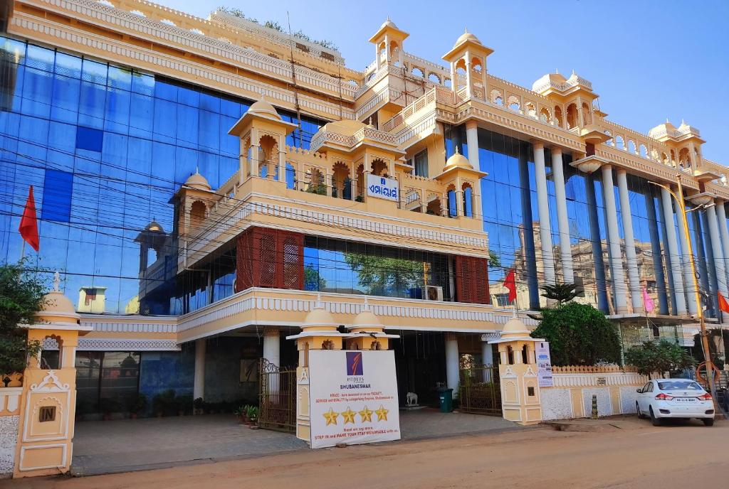 un grand bâtiment avec un panneau devant lui dans l'établissement Hotel Empires, à Bhubaneswar