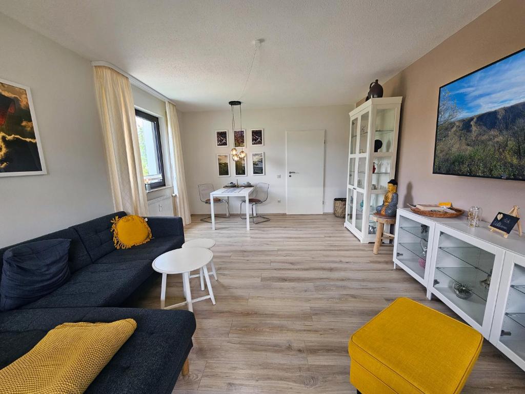 uma sala de estar com um sofá azul e uma mesa em Ferienwohnung Bergblick - a66742 em Bad Sachsa