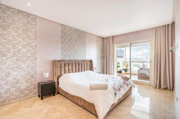 um quarto com uma cama grande e uma janela em Appart 100 m2 haut standing en bord de mer em Casablanca