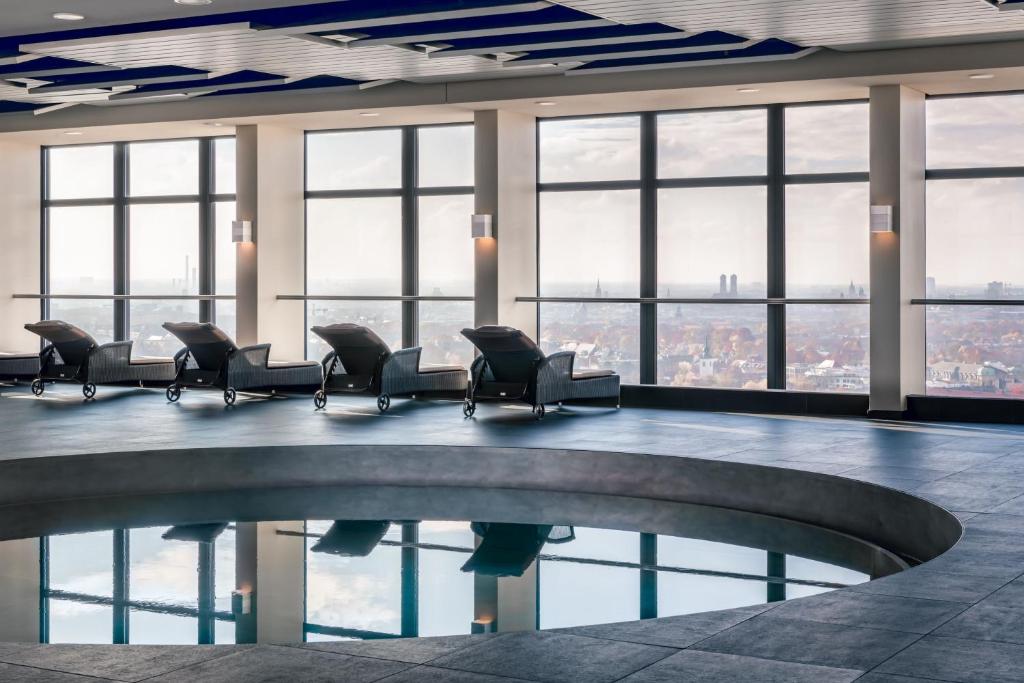 a waiting room with chairs and a pool at Four Points by Sheraton Munich Arabellapark in Munich