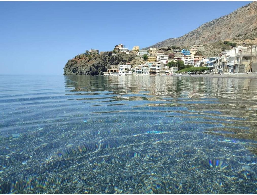 un bacino idrico con un gruppo di edifici sulla riva di Coastline of Paradise a Paránimfoi