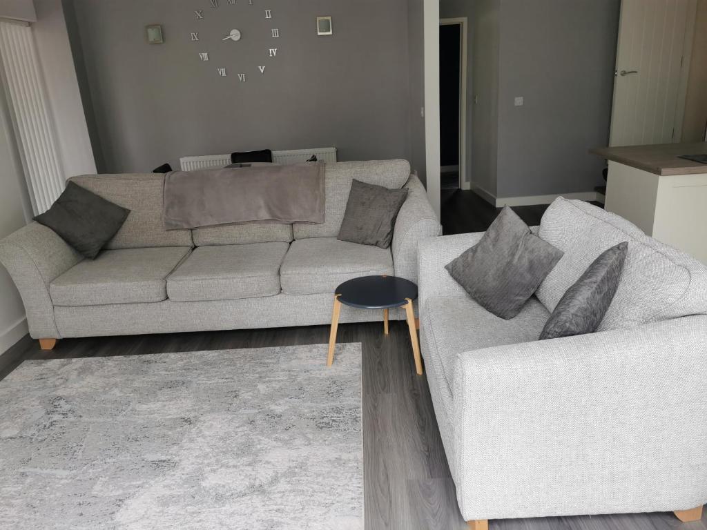 ein Wohnzimmer mit einem Sofa und einem Tisch in der Unterkunft Shepherd's Rest Apartments Central Location With Parking in Tewkesbury