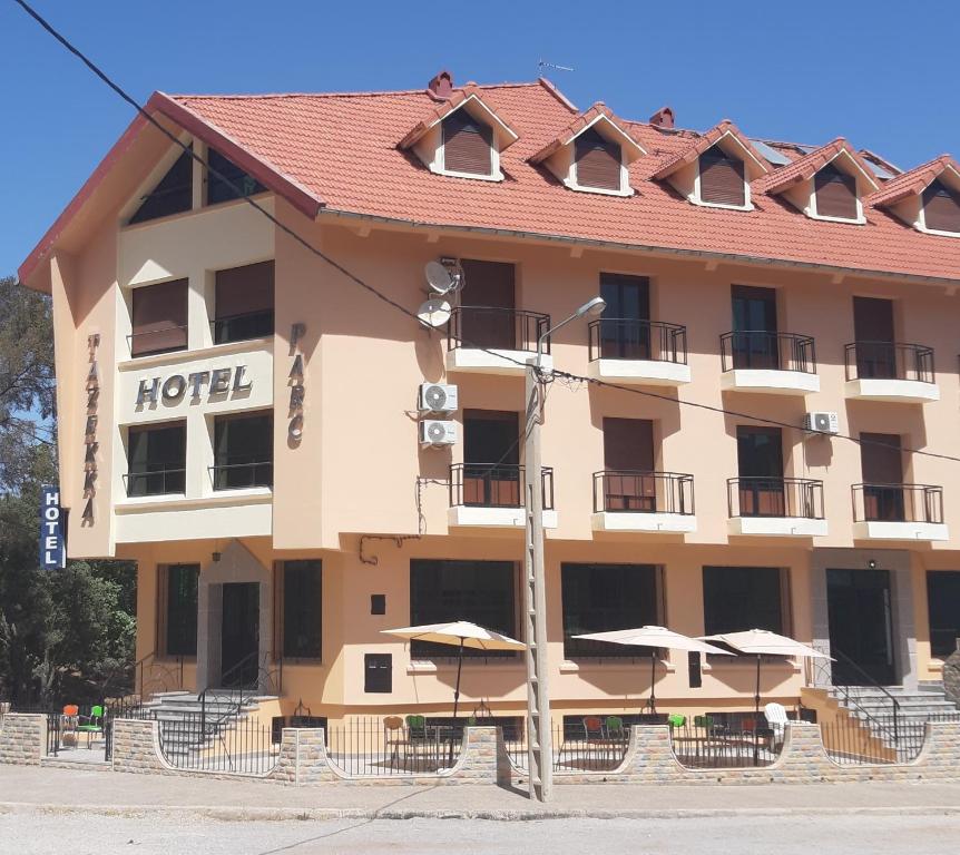 um hotel com mesas e guarda-sóis em frente em TAZEKKA PARC HOTEL em Taza