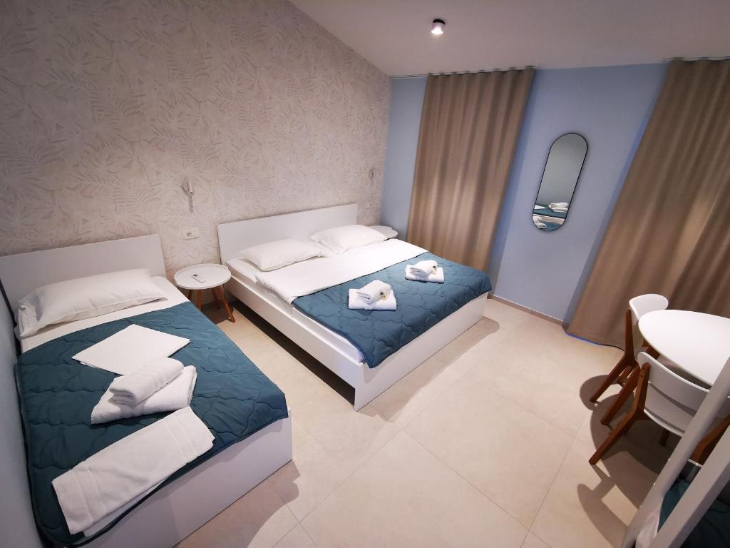 1 dormitorio con 2 camas y lavamanos. en Morski gaj Resort, en Piran