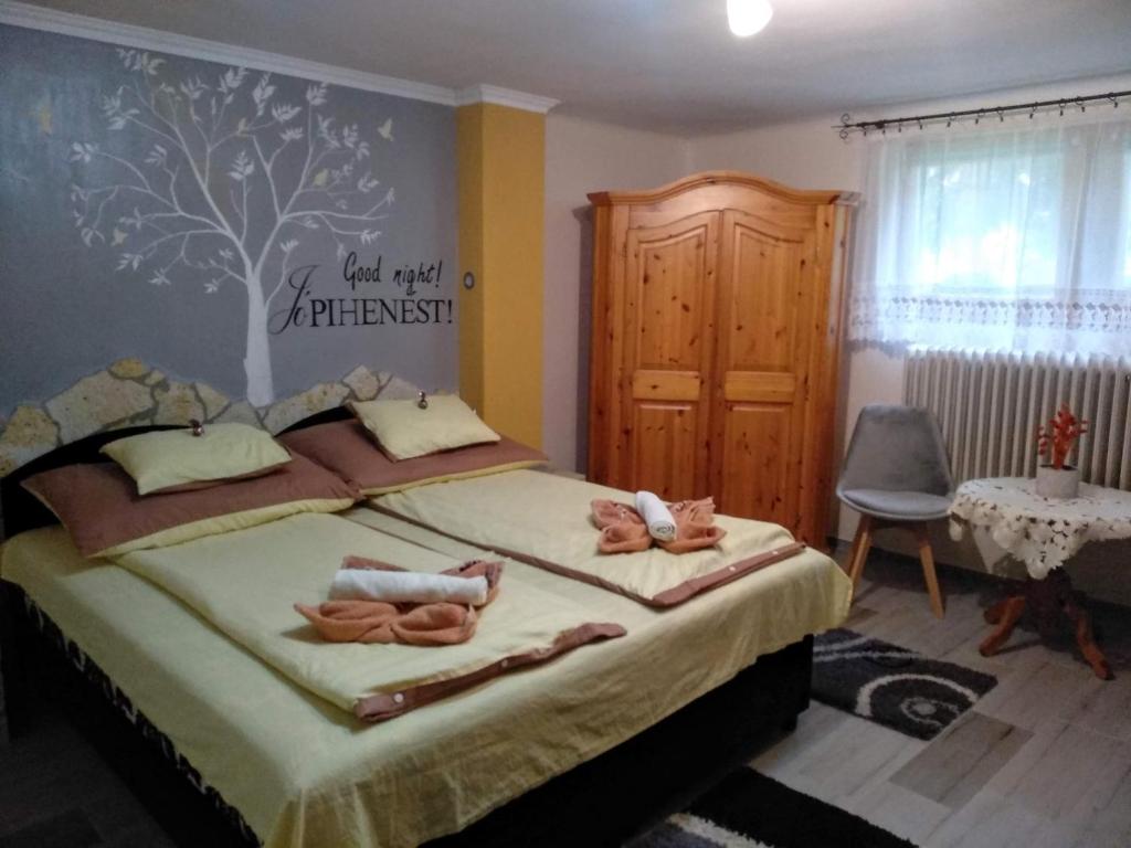 een slaapkamer met een bed met twee poppen erop bij Gréti Apartman in Sárospatak