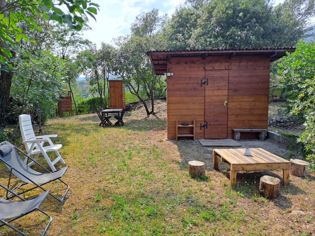a wooden cabin with a table and chairs in a field at Cabane Eco Lodge in Tourrettes-sur-Loup