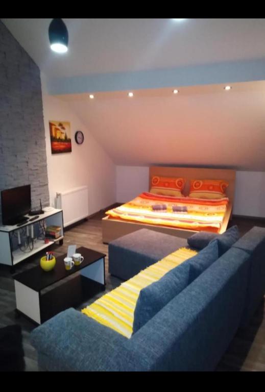 a bedroom with a bed and a blue couch at Happy House in Belgrade