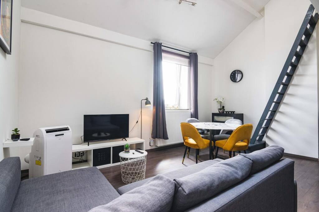 a living room with a couch and a table at Les Figuiers - Appartement de Standing avec 2 Chambres in Andenne