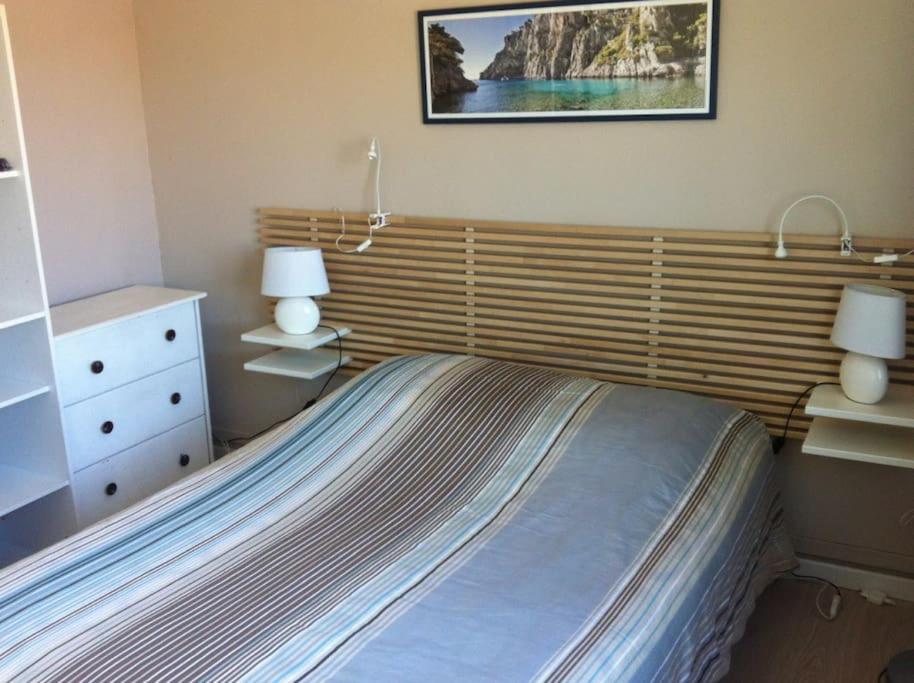 a bedroom with a bed with two lamps on it at Cabanon aux Goudes Marseille calanques in Marseille