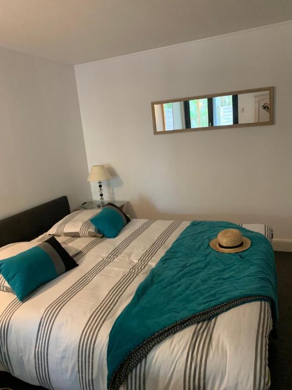 a bedroom with a large bed with a hat on it at L'OCEANE in Royan