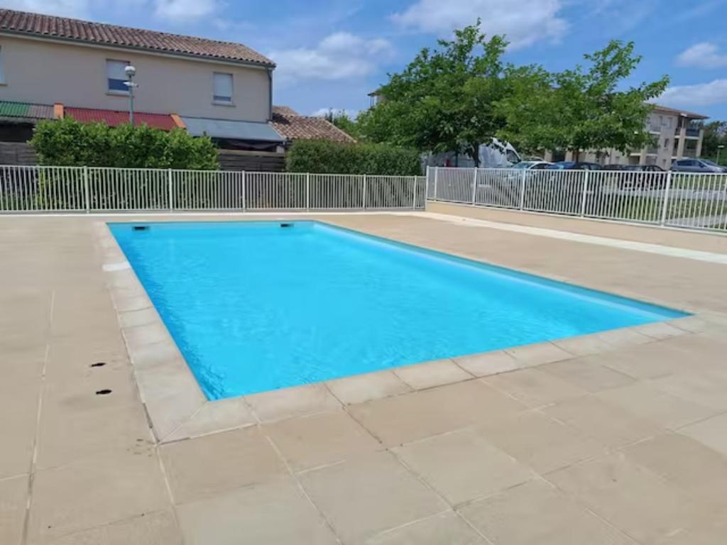 ein großer blauer Pool im Hof in der Unterkunft Le cocon de Marie,piscine, balcon, parking gratuit, baignoire in Carcassonne