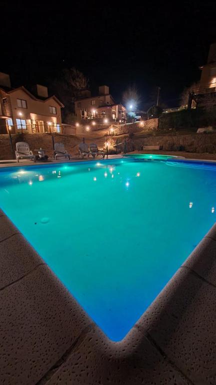 a large blue swimming pool at night at Departamento Cerro Negro in Villa General Belgrano