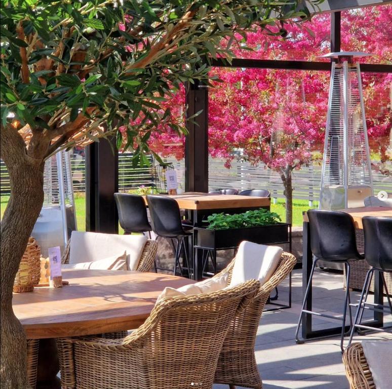 uma mesa e cadeiras num restaurante com flores cor-de-rosa em Aurum Hotel em Skellefteå