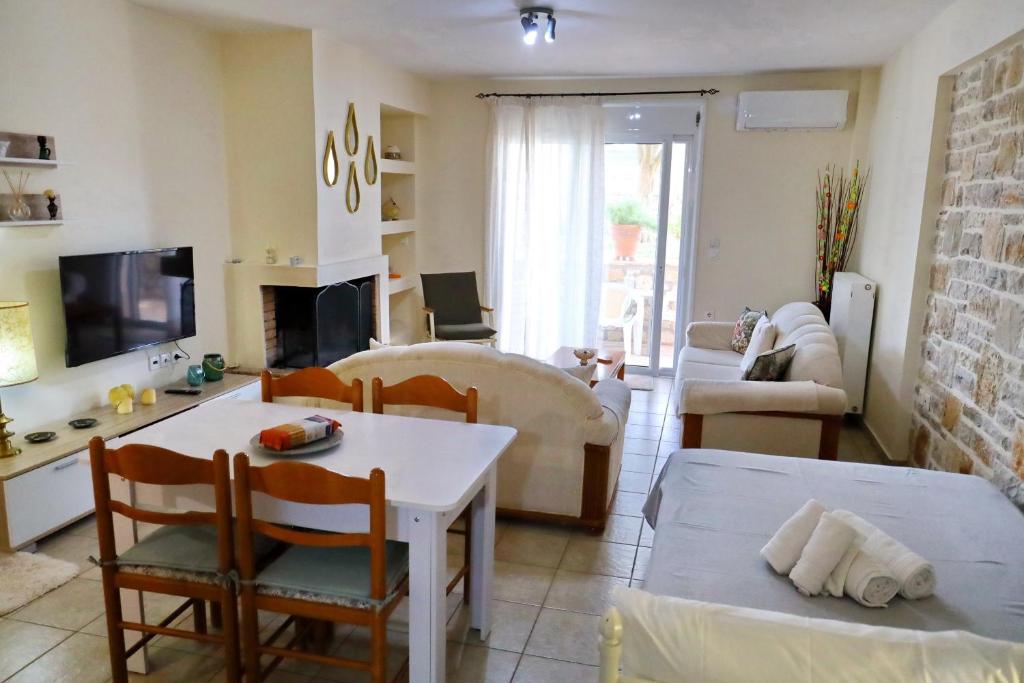 een woonkamer met een witte tafel en stoelen bij Fou's apartment in Nafpaktos