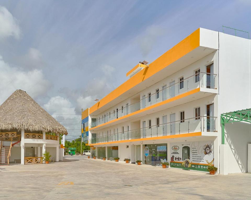 a large white building with a thatch roof at Sun Express Hotel in Pueblo Bavaro