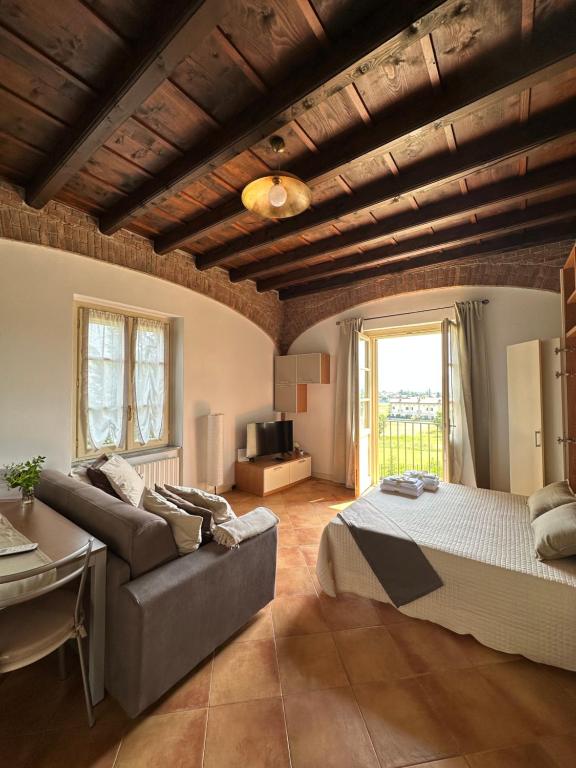a large bedroom with a bed and a couch at Vittoria Apartment in Serravalle Scrivia