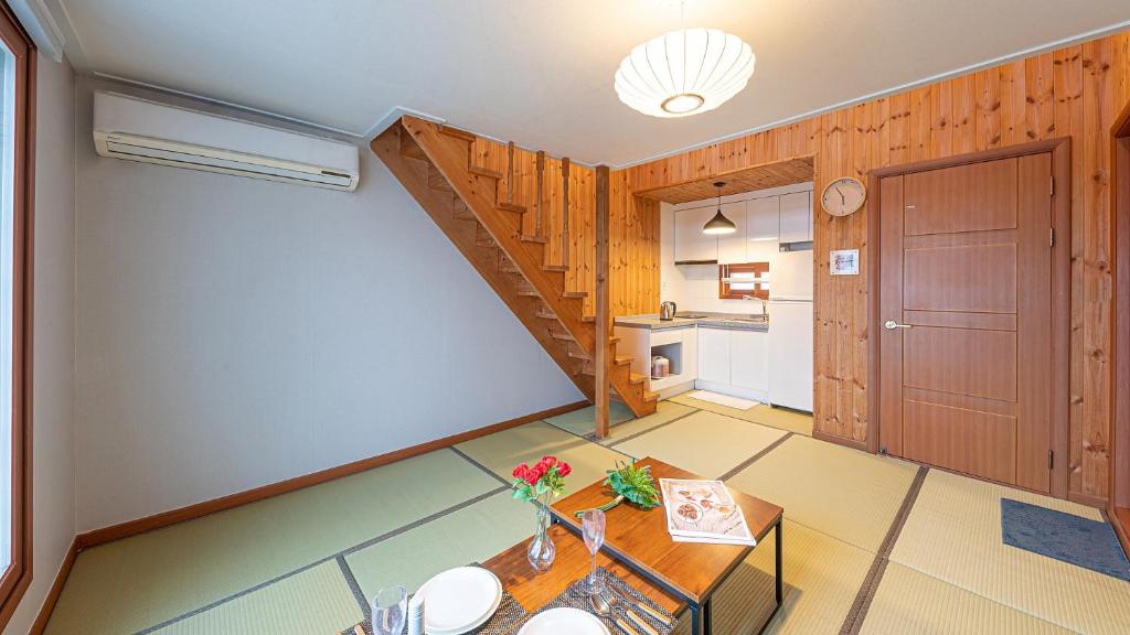 a kitchen with a staircase and a table in a room at Eungabi Pension in Gangneung