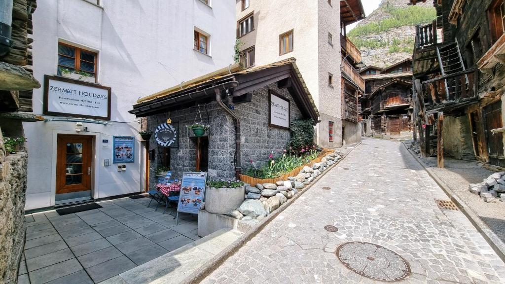 uma rua vazia numa cidade com um edifício em Dent Blanche em Zermatt