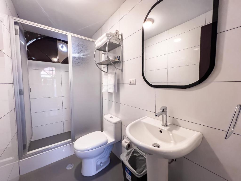 a bathroom with a sink and a toilet and a mirror at Hotel Cusco Plaza Saphi in Cusco