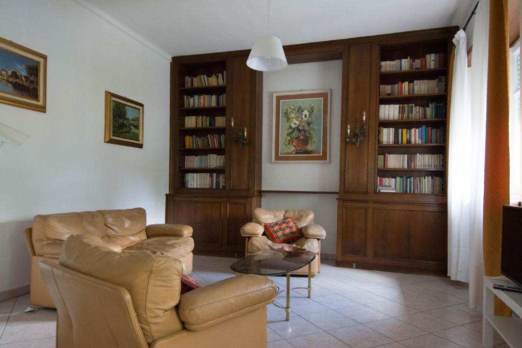 a living room with two chairs and bookshelves at La Casa di Bianca in SantʼAmbrogio di Torino
