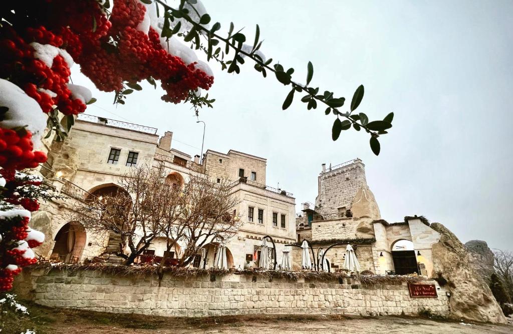 an old castle with snow on the ground at Tafoni Houses Cave Hotel in Ortahisar