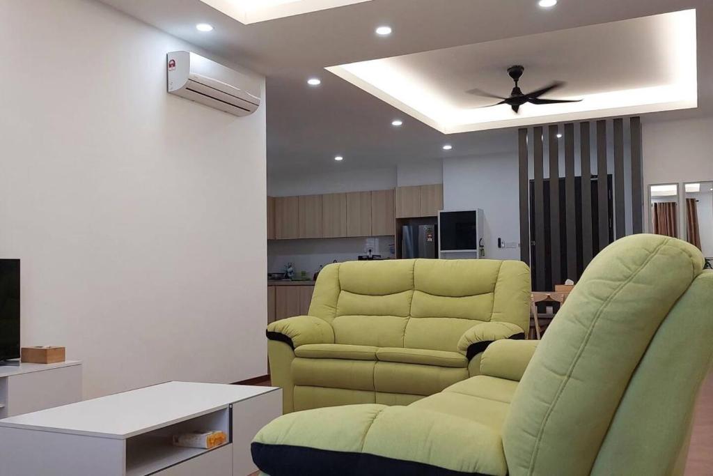 a living room with two chairs and a ceiling fan at Sunsky Condominium Homestay 2 in Miri
