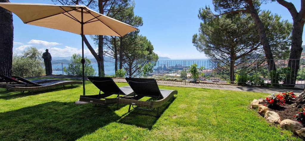 ein Paar Stühle unter einem Regenschirm im Hof in der Unterkunft VillaMara in La Spezia