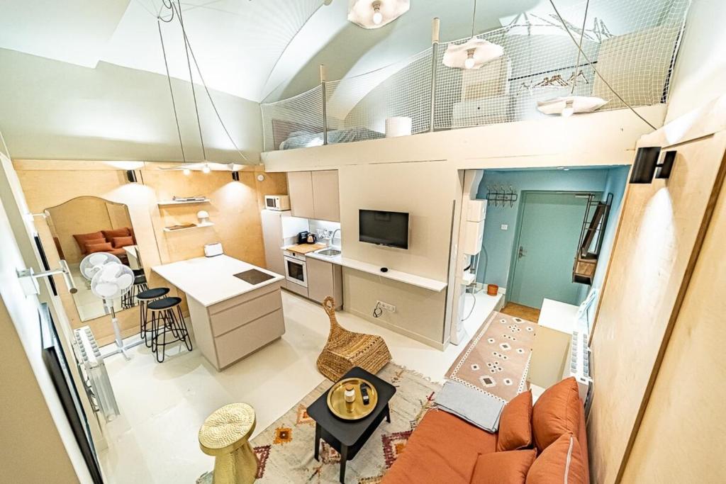un salon et une cuisine ouverts dans un petit appartement dans l'établissement Le petit Chazette - Terreaux Croix Rousse, à Lyon