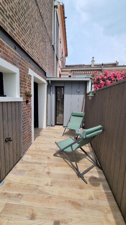 een paar stoelen op een terras bij Au bord de Mers in Mers-les-Bains